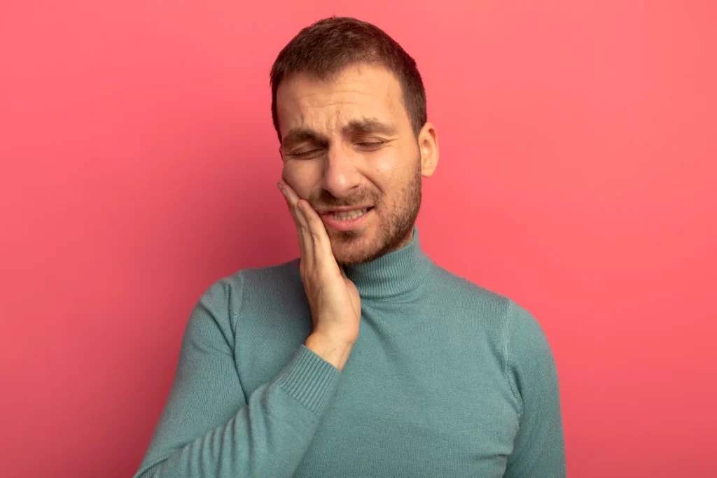 Young man showing discomfort as his teeth hurt after cleaning