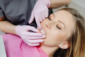 Dentist examining patient for loose permanent tooth in clinic.