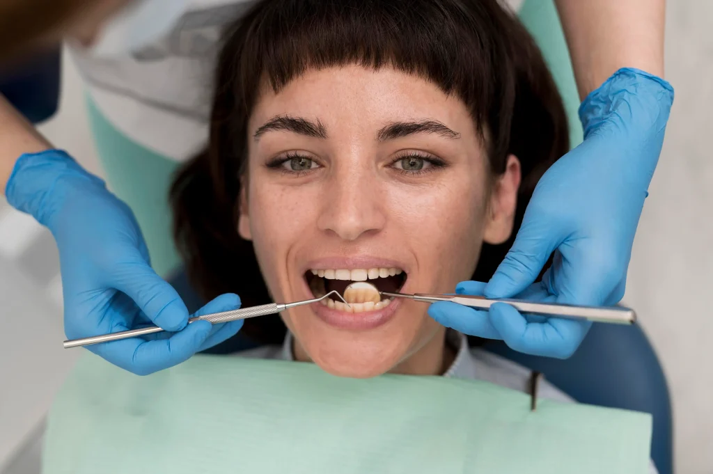 Dentist examining patient’s permanent loose tooth during a close dental check