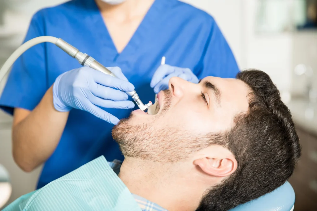 Male patient receiving deep cleaning teeth care at dental clinic