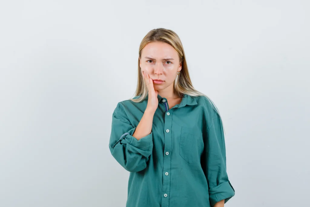 Young woman with mild concern on her face, representing the condition where a tooth falls but it does not hurt