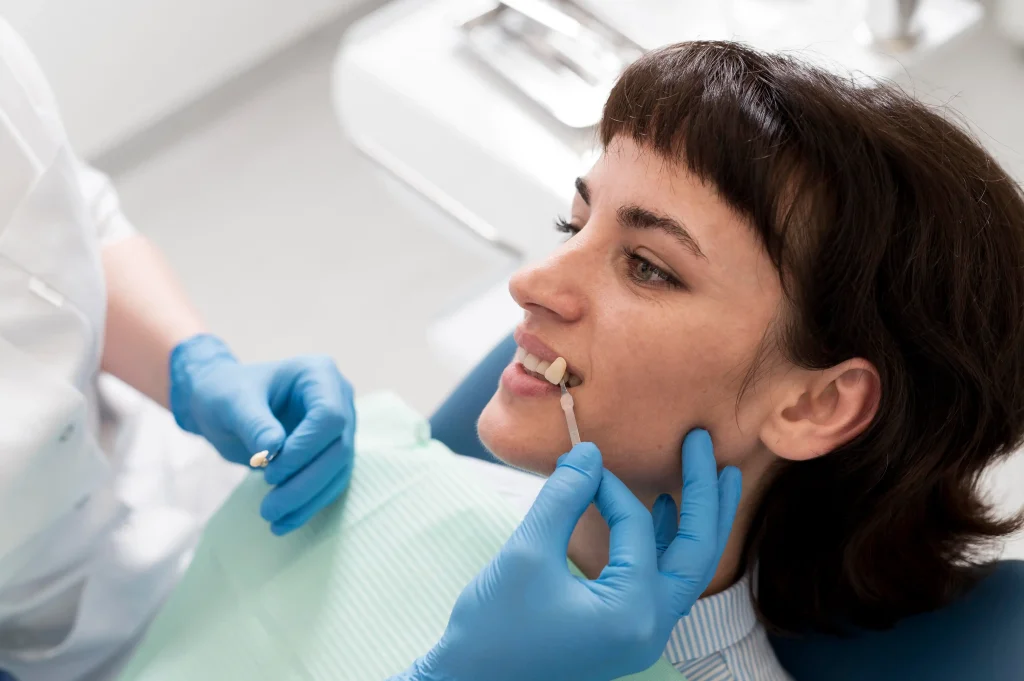 Dentist matching a dental crown shade to a patient's natural teeth