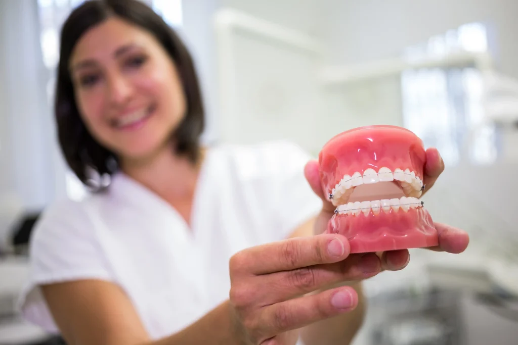 Denture cost consultation with a dentist holding a denture model